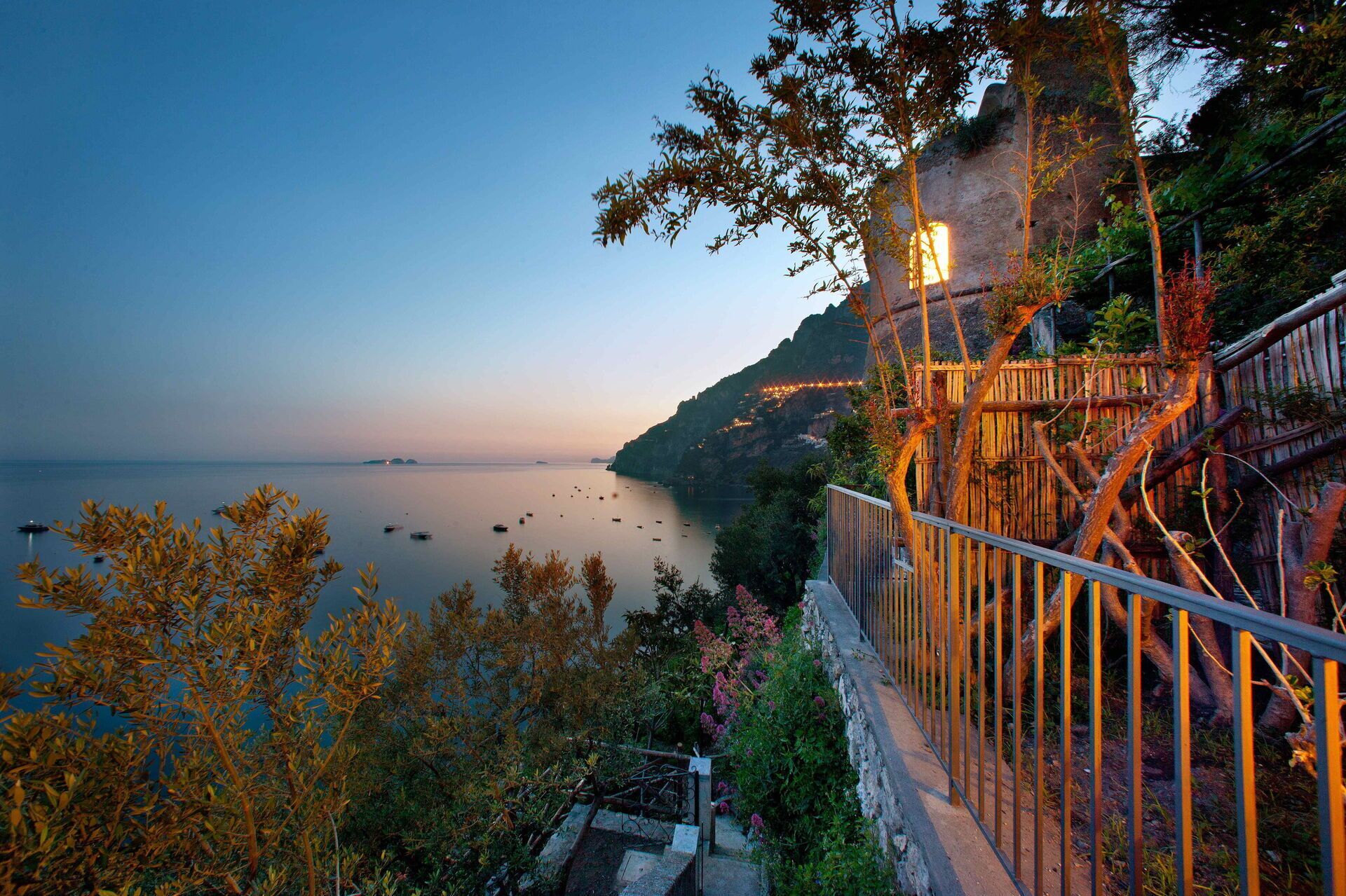 A coastal view with a wooden staircase leading down to a beach.