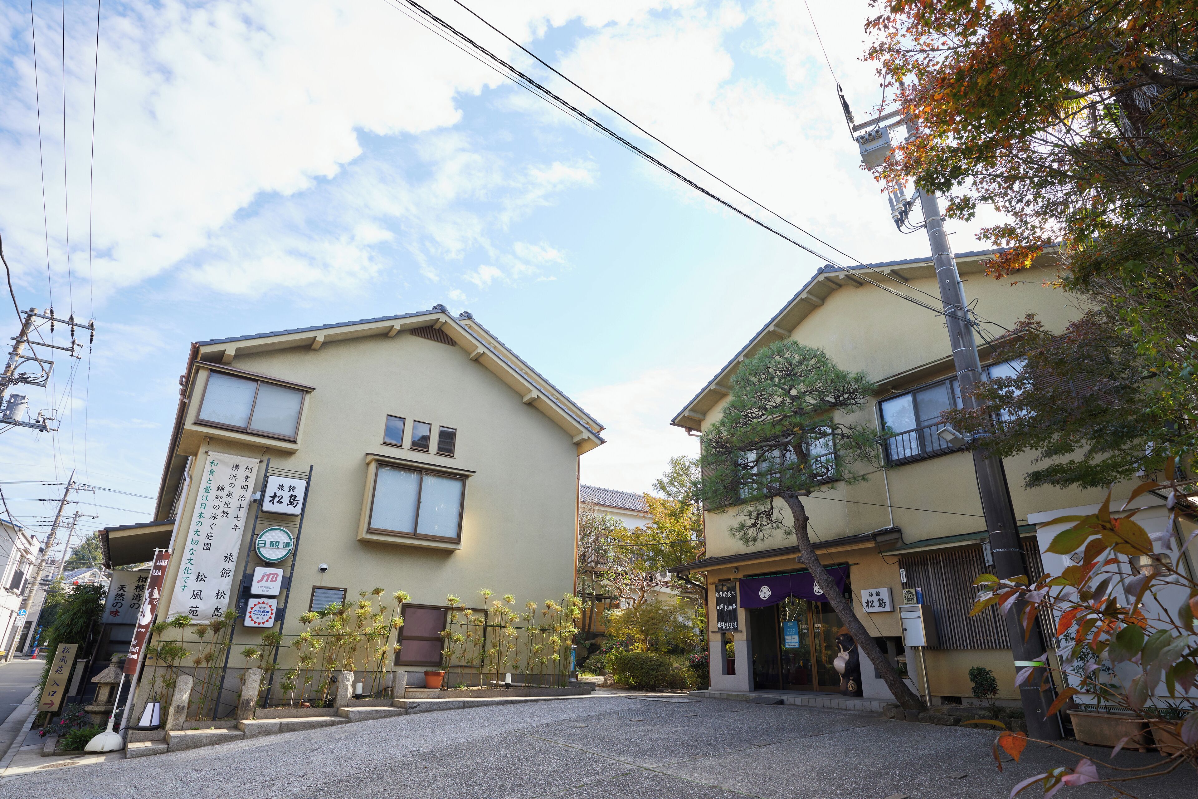 A street view with two buildings, one with a signboard and another with a shop entrance.