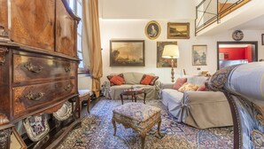 A traditional living room with a large wooden cabinet, a sofa set, a patterned rug, and a staircase leading to an upper level. - Portello Apartment by Geco Vacation Rentals (Genoa)