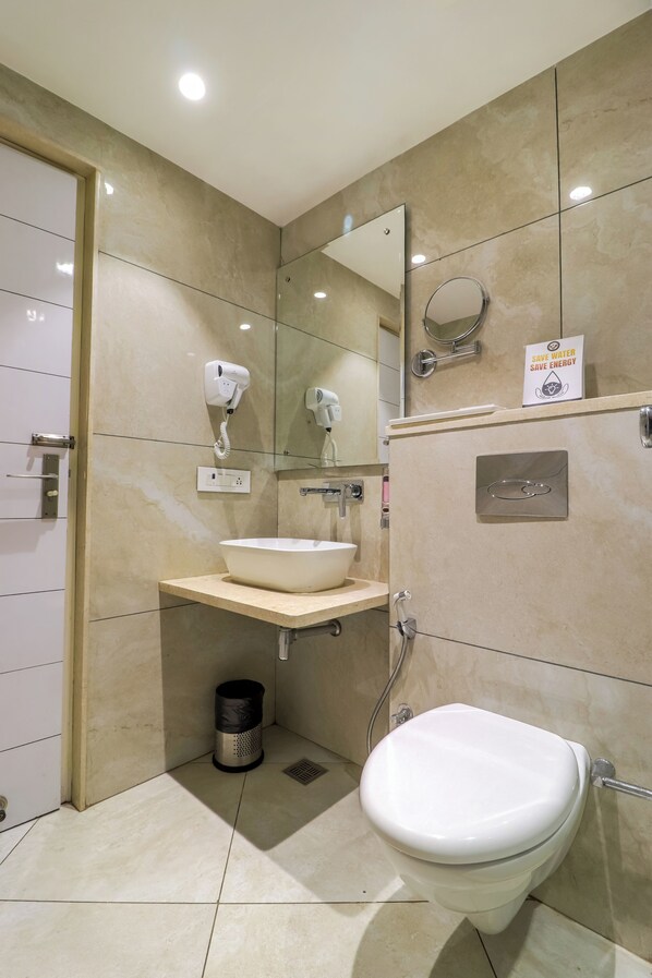 A modern bathroom with a sink, mirror, hairdryer, and a 'Save Water Save Energy' sign.