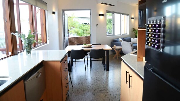 A modern kitchen with a dining area, large windows, and a refrigerator. - Ellen Fremantle City Centre - Walk everywhere. Secure free parking. (Fremantle)