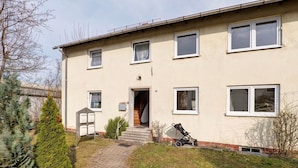 A two-story building with a paved entrance, a staircase, and a stroller parked outside. - Apartment 'C' in Miltenberg (Miltenberg)