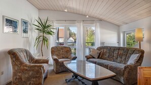 A room with a wooden ceiling, two armchairs, a sofa, a glass-top coffee table, and a potted plant. - Studio 'Brend, 48qm' with Balcony and Wi-Fi (Schönwald im Schwarzwald)