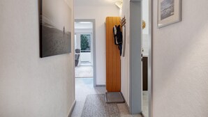 A hallway with a wooden door, a coat rack, and a framed picture on the wall. - Studio 'Hörnleberg, 80qm' with Balcony and Wi-Fi (Schönwald im Schwarzwald)