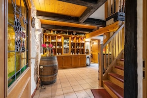 A wooden interior with a wine rack, a barrel, and a staircase.