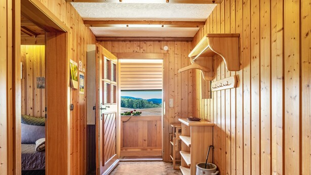 A wooden interior with a hallway leading to a balcony with a view. - Apartment 'Talblick' with Mountain View, Private Terrace and Wi-Fi (Wolfach)