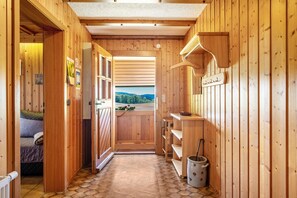 Interior de madera con un pasillo que lleva a un balcón con vistas.
