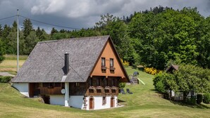 A house with a sloped roof, a chimney, and a balcony with flower boxes. - Apartment 'Talblick' with Mountain View, Private Terrace and Wi-Fi (Wolfach)