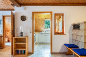 A wooden interior with a kitchen, a bookshelf, and a bench. - Apartment 'Fuchsbau' with Mountain View, Private Terrace and Wi-Fi (Wolfach)