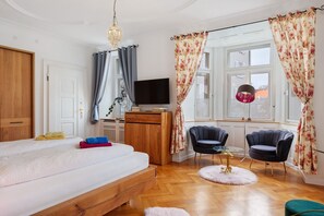 A bedroom with a bed, a TV, a wooden wardrobe, a desk, two chairs, a round table, and a window with curtains. - Apartment 'Uwe's Stube' with Shared Terrace, Shared Garden and Wi-Fi (Lenzkirch)