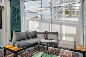 A modern interior with a sectional sofa, a round table, and a wooden bench.