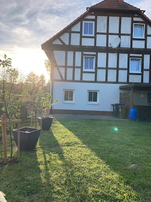 A traditional half-timbered house with a well-maintained lawn and potted plants. - Apartment 'Wie Zu Hause' with Shared Garden and Wi-Fi (Ostritz)