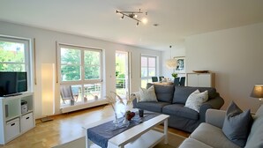 Ein geräumiges Wohnzimmer mit einer Couch, einem Couchtisch und einem Fernseher.