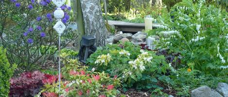 A garden with various plants and a wooden structure.