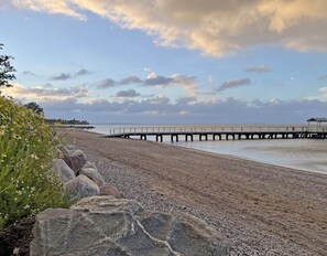 A beach with a pier extending into the water, surrounded by rocks and vegetation. - Apartment 'Ferienwohnung Ankerleicht' with Shared Terrace, Shared Garden and Wi-Fi (Steinbergkirche)
