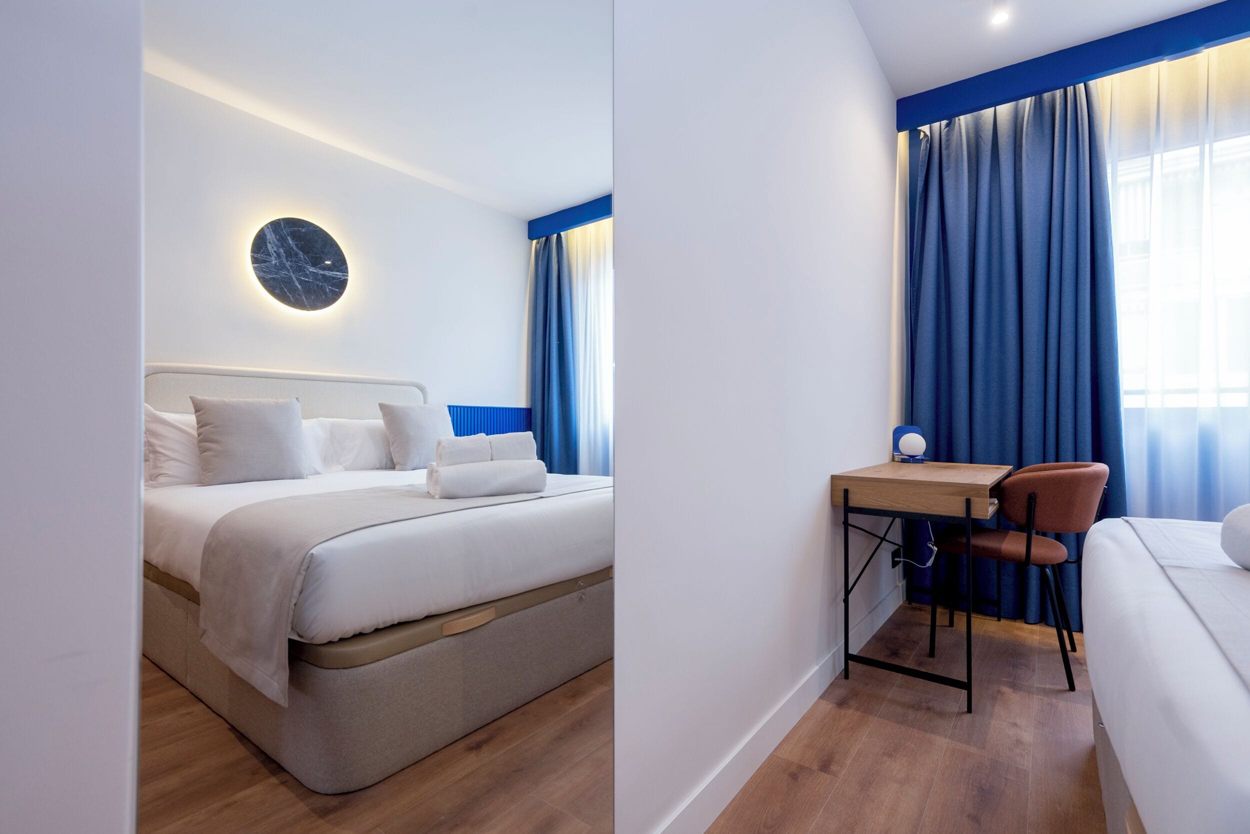 Una habitación de hotel moderna con una cama, un escritorio y una silla.