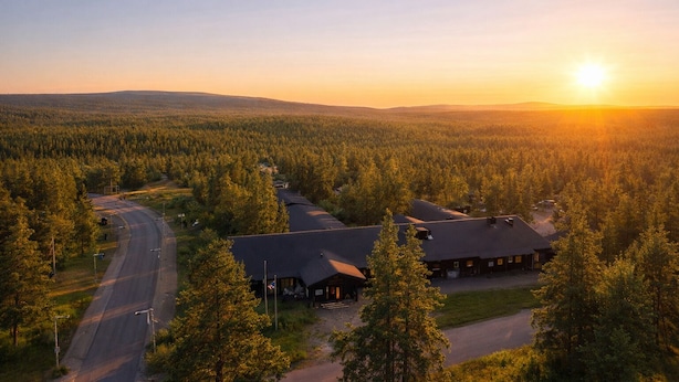 A lodge with a road leading to it, surrounded by dense forest. - Wilderness Hotel Kieppi (Saariselkä)