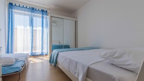 A bedroom with a bed, a chair, and a wardrobe. - Apartment Mirta 1 (Dramalj)