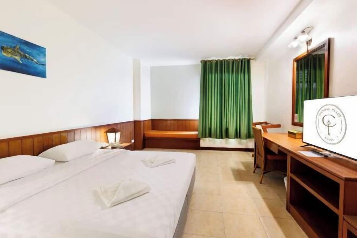 Ein Hotelzimmer mit Bett, Schreibtisch, Stuhl, Fernseher und einem Gemälde an der Wand.