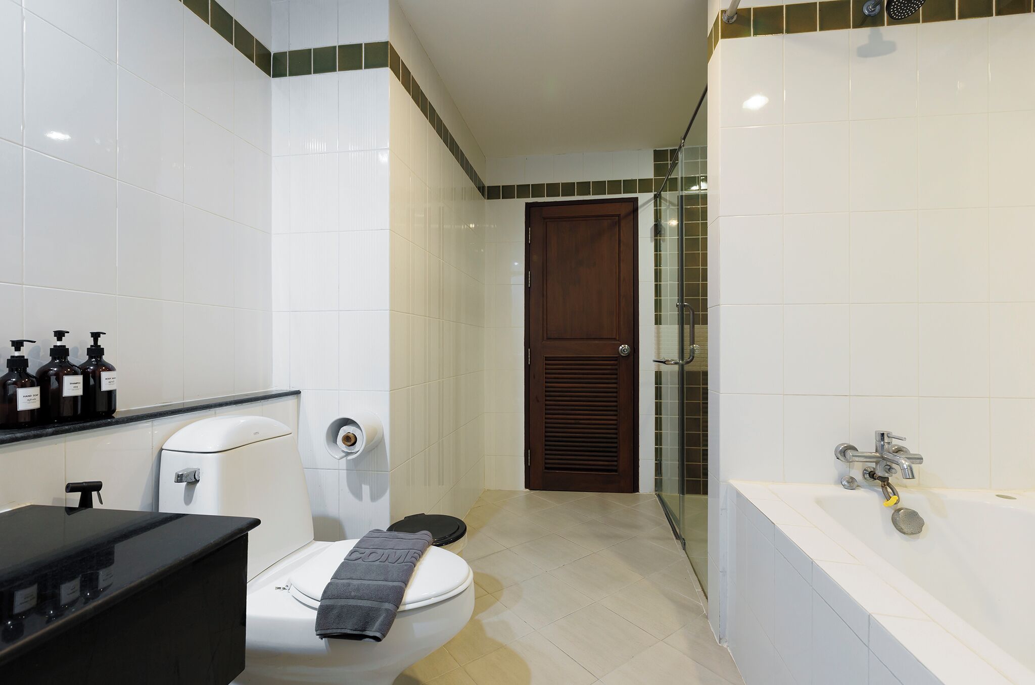 Une salle de bain avec des toilettes, un lavabo et une baignoire.