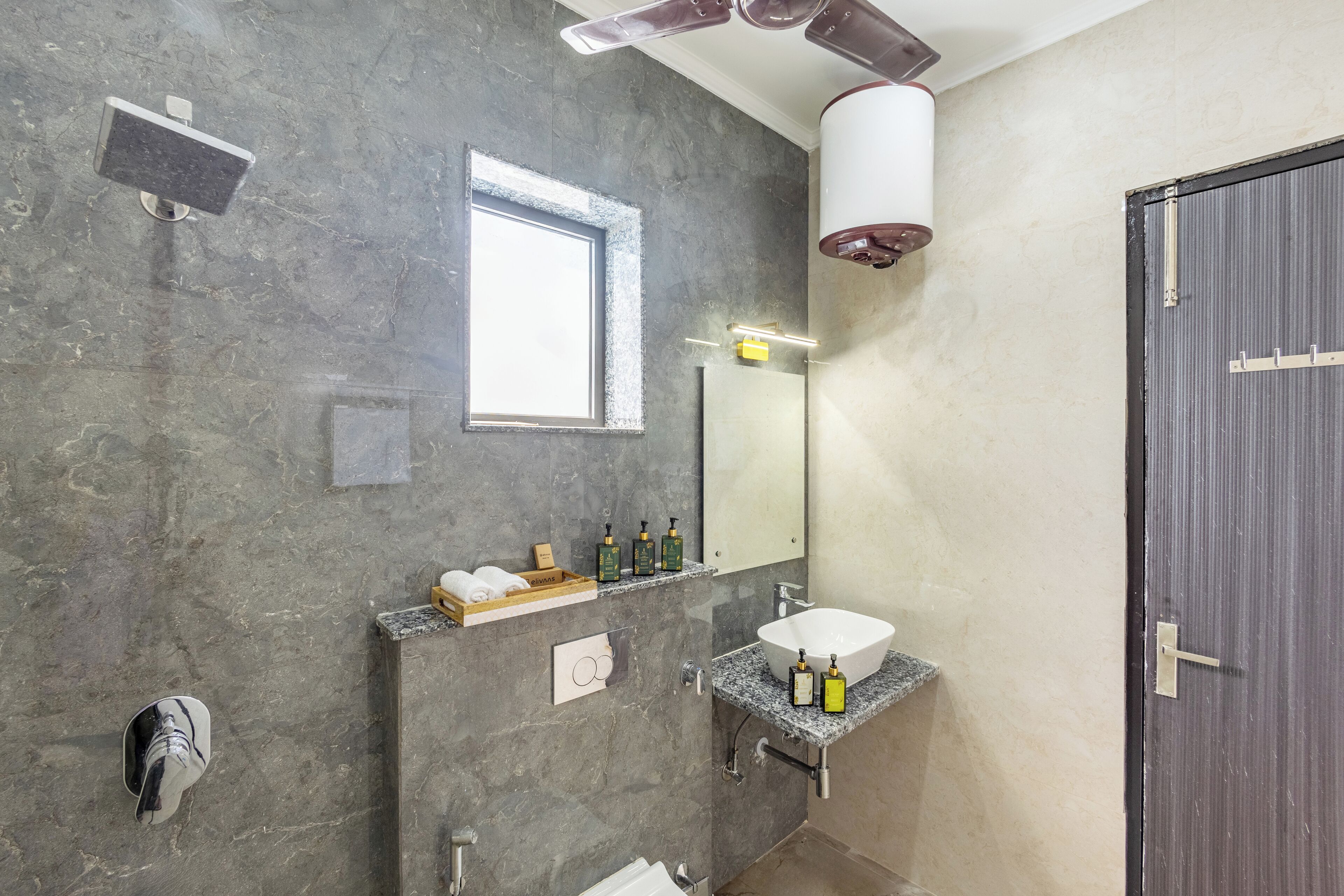 A modern bathroom with a large mirror, a built-in sink, and a shower area.