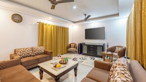 Una sala de estar con un sofá, una mesa de centro con frutas, un televisor de pantalla plana y una chimenea.