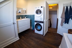 Une buanderie équipée d’un lave-linge, d’un sèche-linge et d’un évier.