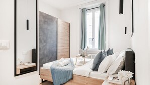 Un dormitorio moderno con una cama de madera, una mesita de noche, un espejo y una ventana con cortinas.