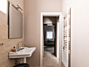 A bathroom with a sink, mirror, and towel rack. - Nido di Noto (Noto)