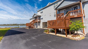 A two-story residential building with a wooden deck and a garage.
