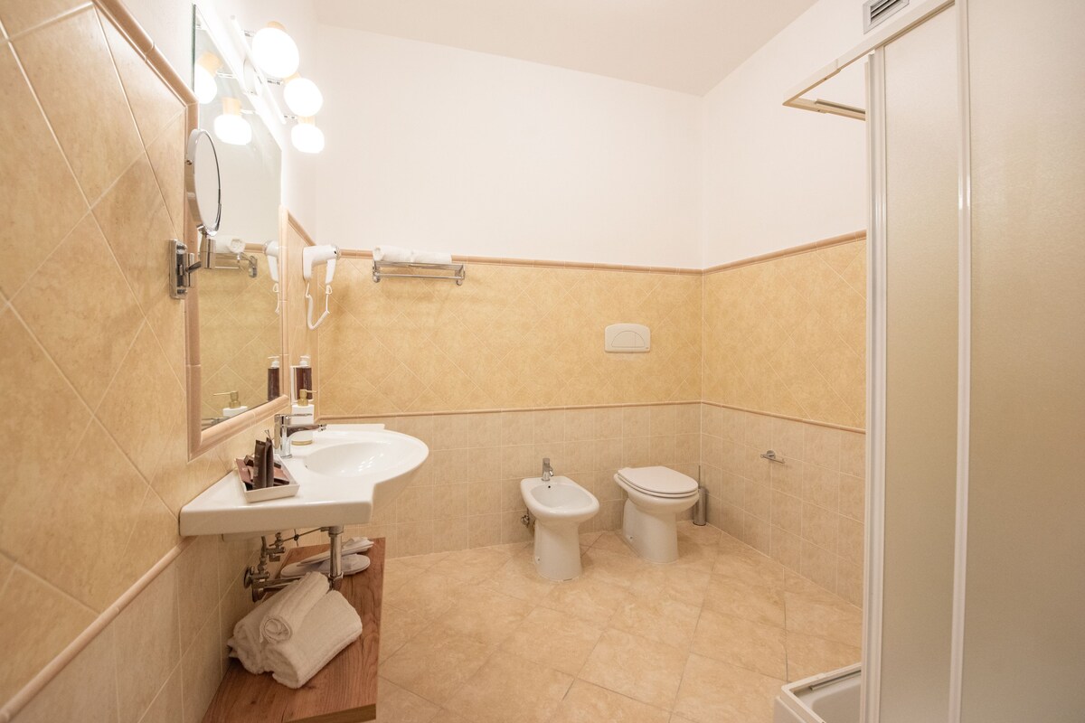 Un baño con lavabo, espejo, toallero y zona de ducha.