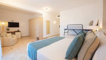 Ein Schlafzimmer mit Bett, Schreibtisch, Stuhl, Fernseher und Kleiderschrank.