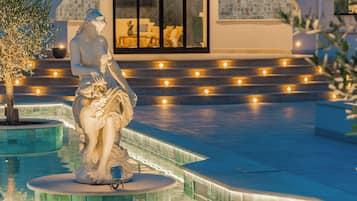 Eine Statue in einem Pool vor einem modernen Gebäude im Hintergrund.