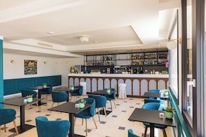 A restaurant interior with a bar area, seating arrangements, and a patterned floor. - CDSHotels Le Castella - Ninfe Saracene (Le Castella)