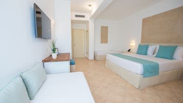 Una habitación de hotel con cama, sofá, escritorio y televisor.