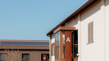A modern building with a clear entrance, marked with letters A and B, and a sign indicating 'Villa Madère San Rossore Apartments.'