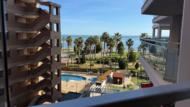 Un immeuble de grande hauteur offrant une vue sur une plage et des palmiers.