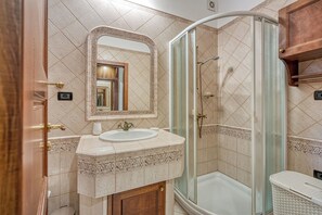 A bathroom with a sink, mirror, and shower.