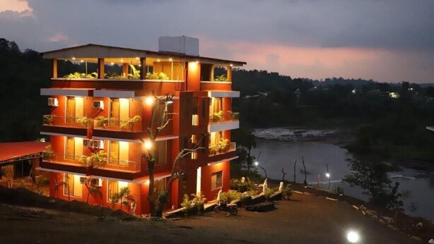 Un edificio de varios pisos con balcones, cerca de una masa de agua.