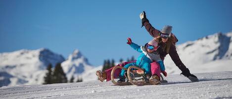 A snowy landscape with a sledding activity.