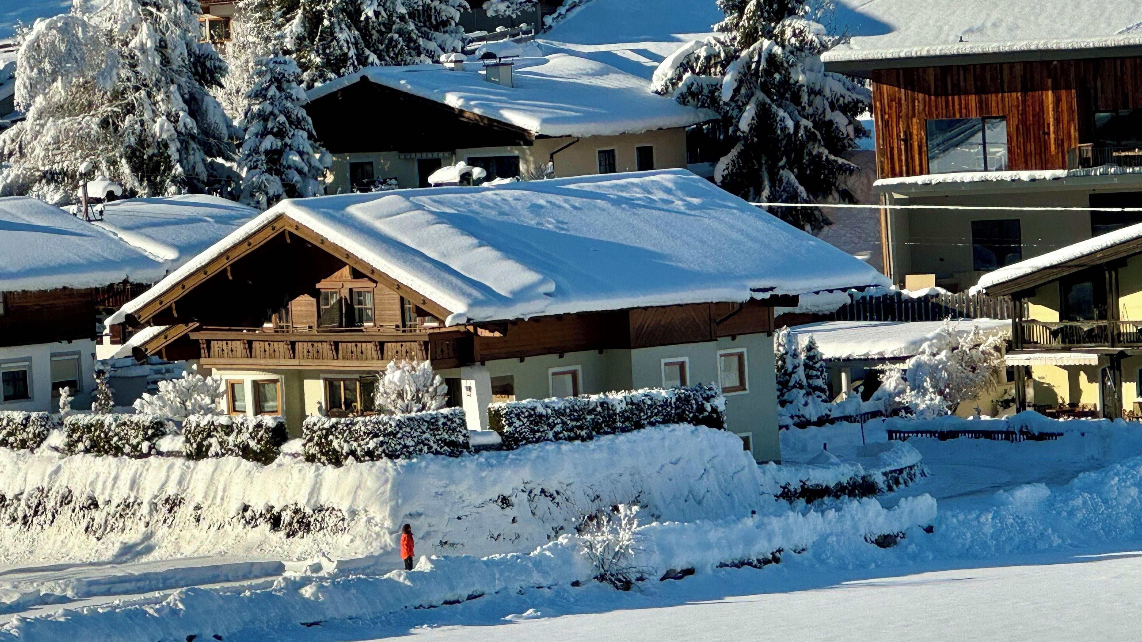 Un bâtiment enneigé, doté d’une façade en bois, de grandes fenêtres et d’un balcon.
