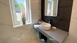 A modern bathroom with a large window, a round sink, and a dark textured wall. - Villa Linda 2 (Crikvenica)