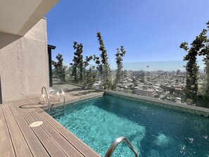 A rooftop pool with clear blue water, surrounded by a wooden deck and glass railings. - Modern Studio - City Views, Fast Wifi & Parking (Santiago)
