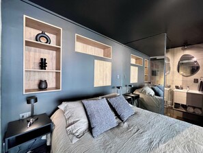 A modern bedroom with a bed, bedside tables, and built-in shelving. - Artistic Urban Apt Santa Elvira | Terrace & WiFi (Santiago)