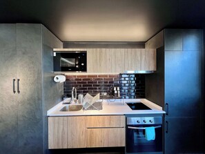A modern kitchen with a built-in microwave, stainless steel sink, and a double oven. - Artistic Urban Apt Santa Elvira | Terrace & WiFi (Santiago)