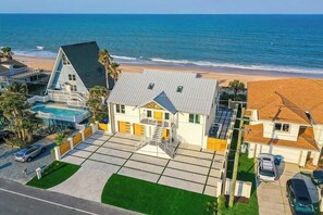 Une propriété située en bord de mer, comprenant une grande maison, une piscine et une vue sur l’océan.