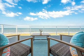 Une terrasse avec une table et des chaises, donnant sur un plan d’eau.