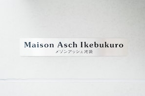 A sign with the name "Maison Asch Ikebukuro" and Japanese text below it. - Maison Ash Ikebukuro by Tranova (Tokyo)