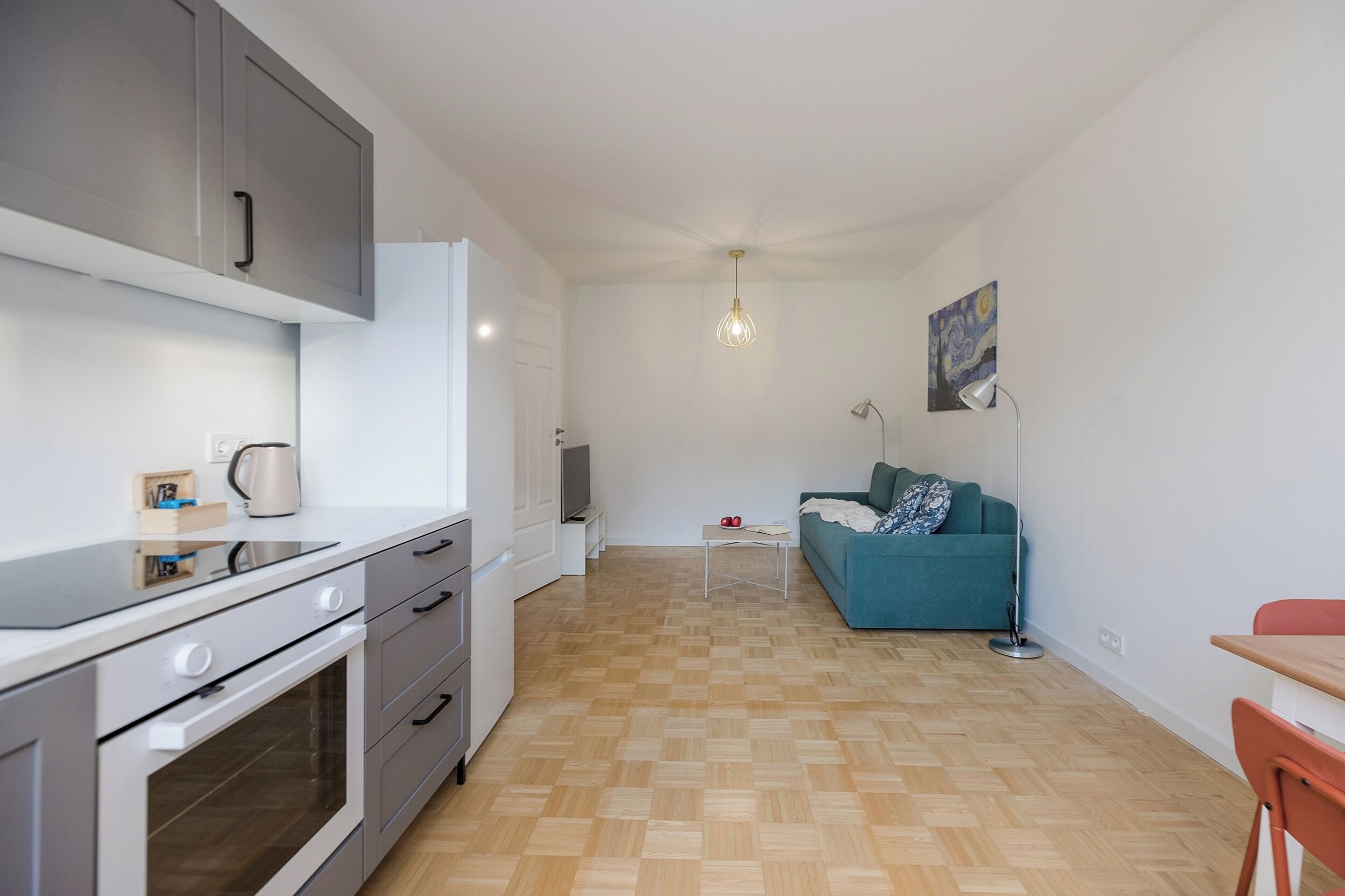 A compact living space with a kitchenette, a sofa, and a dining area.