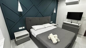 Ein modernes Schlafzimmer mit einem großen Bett, einem Fernseher und einer eingebauten Klimaanlage.